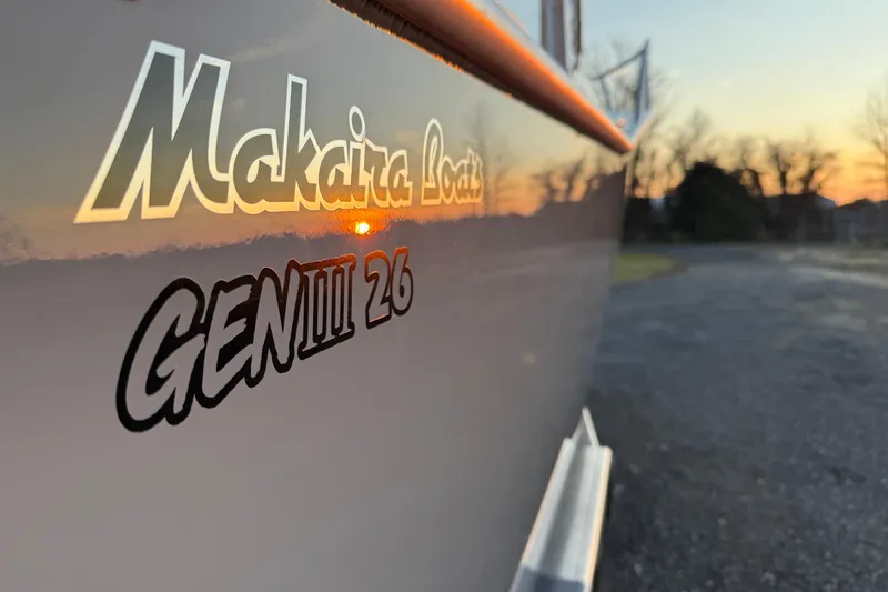 Slide: The Image of 2026 Makaira Gen3 26 Outboard boat with sunset reflection on hull. - 50