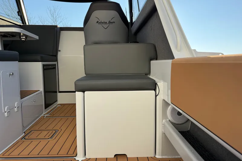 Slide: The Image of Interior of 2026 Makaira Gen3 26 Outboard boat with modern seating and wood flooring. - 9