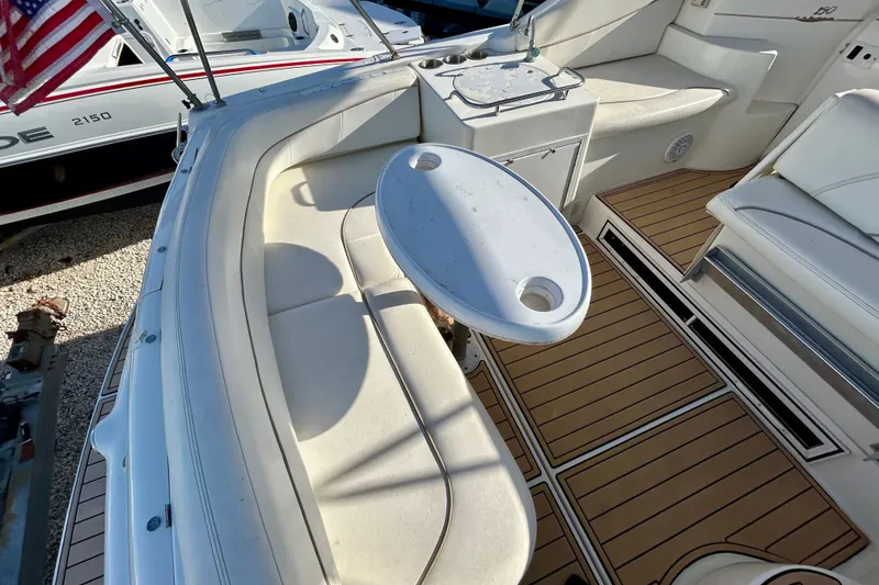 Slide: The Image of 2000 Larson 290 Cabrio boat interior with seating and table, featuring wood-style flooring. - 15