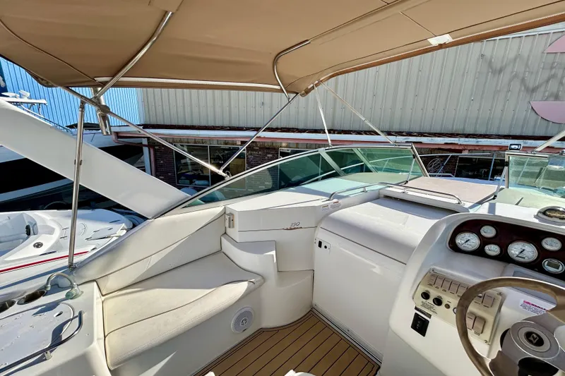 Slide: The Image of 2000 Larson 290 Cabrio boat cockpit with steering wheel and gauges, under a canopy. - 16