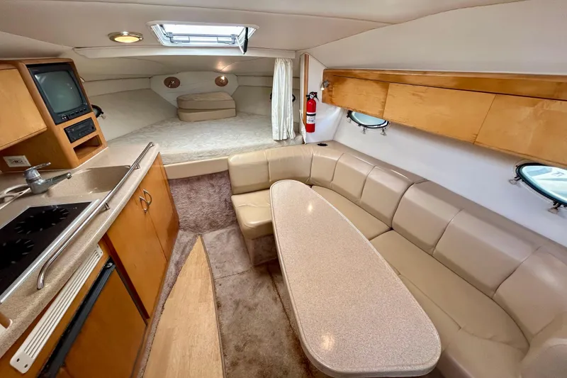 Slide: The Image of Interior of 2000 Larson 290 Cabrio boat with kitchenette, seating, and sleeping area. - 3