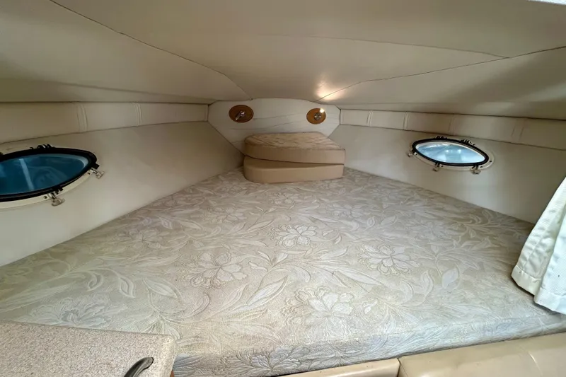 Slide: The Image of Cozy cabin interior of 2000 Larson 290 Cabrio boat with floral-patterned bedding. - 6