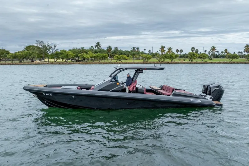 The Image of 2023 Skipper-BSK 42 boat on water, sleek design, overcast sky, lush shoreline. - 2