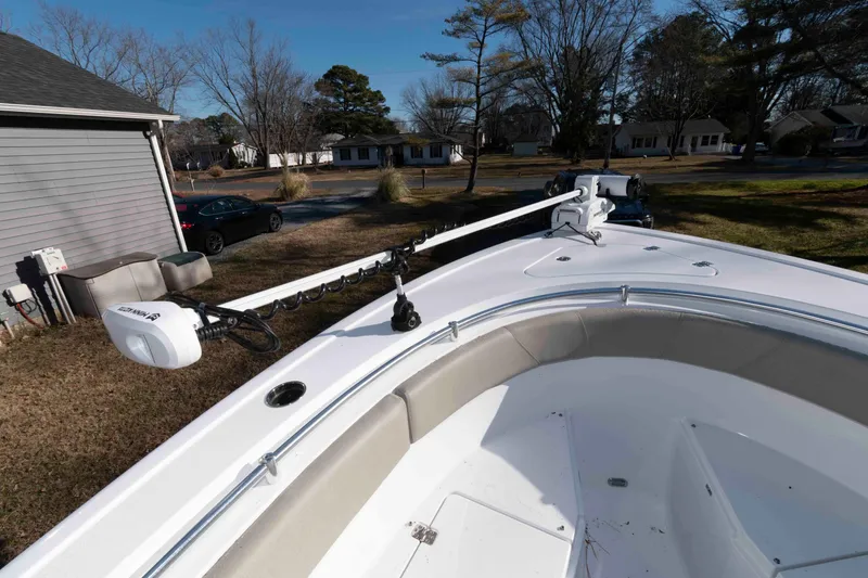 Slide: The Image of 2024 Sportsman Open 252 Center Console boat with trolling motor, parked in residential area. - 12