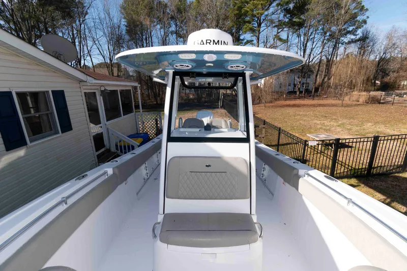 Slide: The Image of 2024 Sportsman Open 252 Center Console boat in a residential backyard setting. - 13