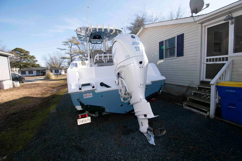 Slide: The Image of 2024 Sportsman Open 252 Center Console boat with powerful outboard motor in residential driveway. - 17