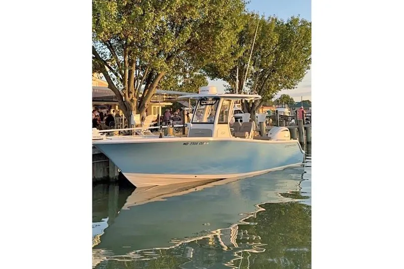 Slide: The Image of 2024 Sportsman Open 252 Center Console boat on trailer, parked outdoors. - 2