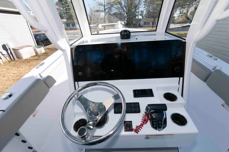 Slide: The Image of 2024 Sportsman Open 252 Center Console boat dashboard with steering wheel and controls. - 8