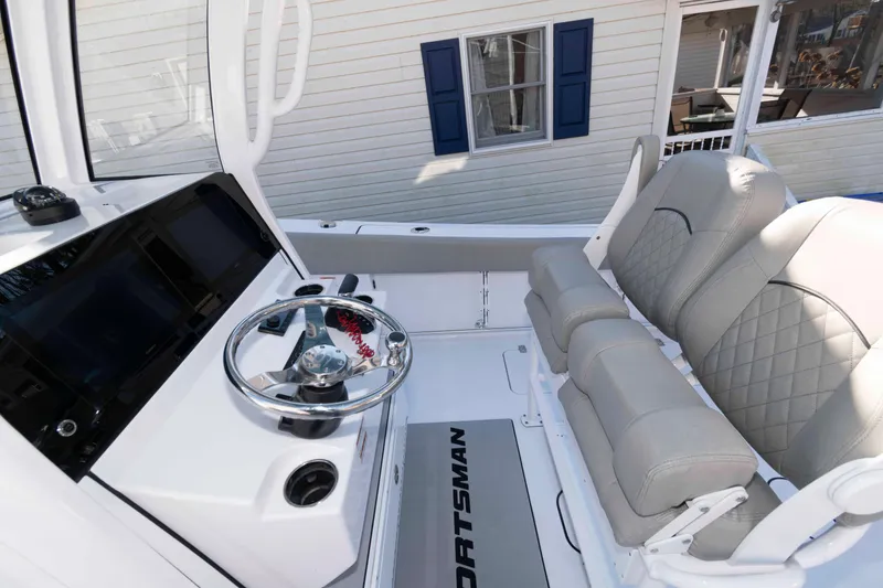 Slide: The Image of 2024 Sportsman Open 252 Center Console boat interior with steering wheel and cushioned seats. - 9