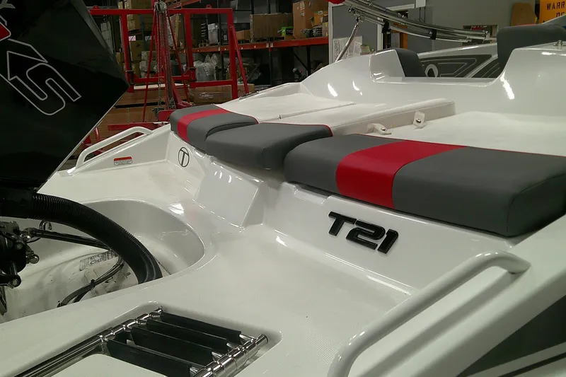 Slide: The Image of 2025 Tahoe T21 boat interior with red and gray seating in a workshop setting. - 4
