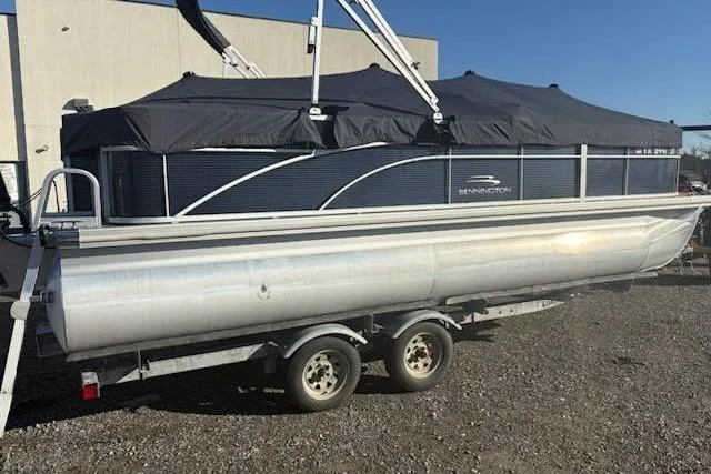Slide: The Image of 2020 Bennington 21SSX pontoon boat on trailer, covered and parked outdoors. - 10