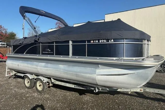 Slide: The Image of 2020 Bennington 21SSX pontoon boat on trailer, covered and parked outdoors. - 11