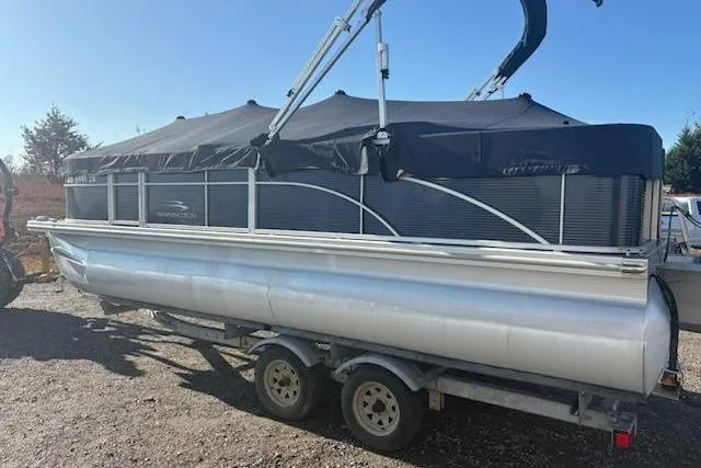 Slide: The Image of 2020 Bennington 21SSX pontoon boat on trailer, covered and parked outdoors. - 14
