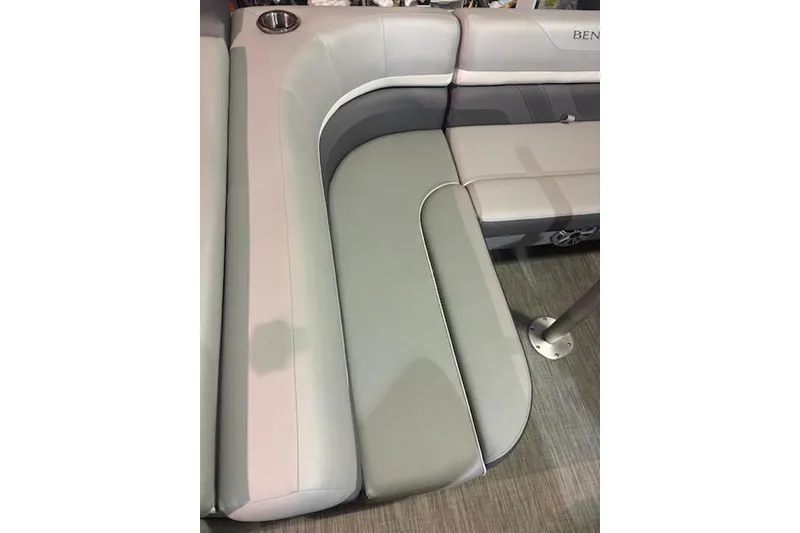 Slide: The Image of 2020 Bennington 21SSX boat interior seating with cup holder, featuring gray and white upholstery. - 18