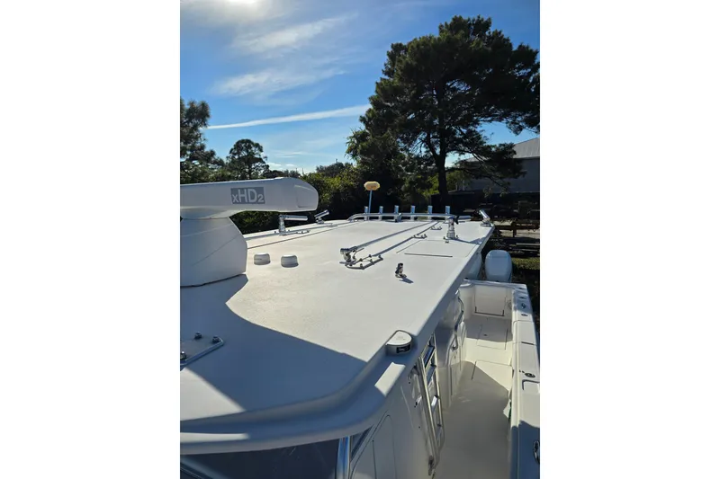 Slide: The Image of 2013 Invincible 42 Open Fisherman boat with radar, sunny day, trees in background. - 13