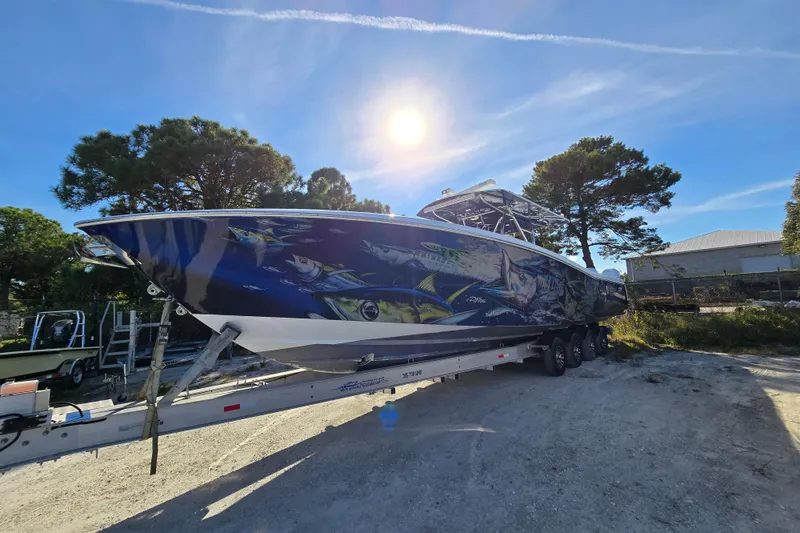 Slide: The Image of 2013 Invincible 42 Open Fisherman boat with vibrant marine-themed hull design. - 2