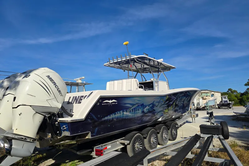 Slide: The Image of 2013 Invincible 42 Open Fisherman boat with vibrant marine graphics on a trailer. - 3