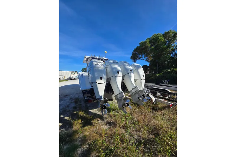 Slide: The Image of 2013 Invincible 42 Open Fisherman with triple outboard engines, parked outdoors. - 6