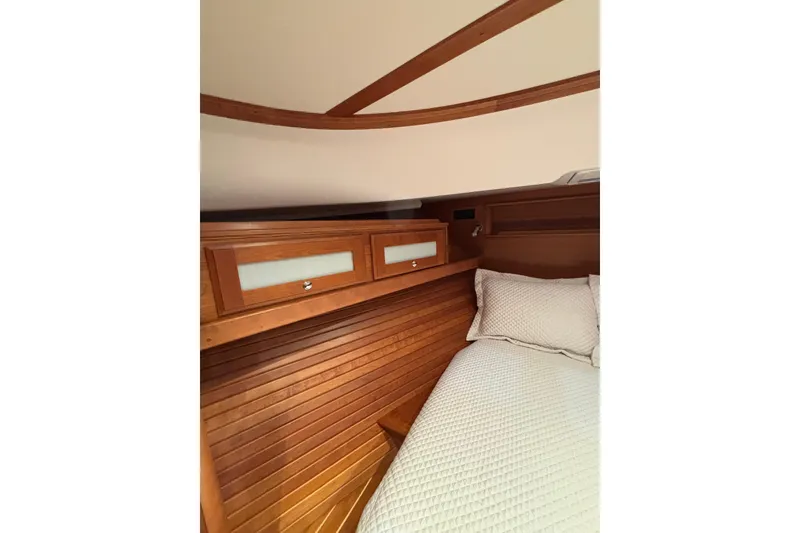 Slide: The Image of 2020 Sabre 45 Salon Express cabin interior with wooden paneling and cozy bedding. - 47