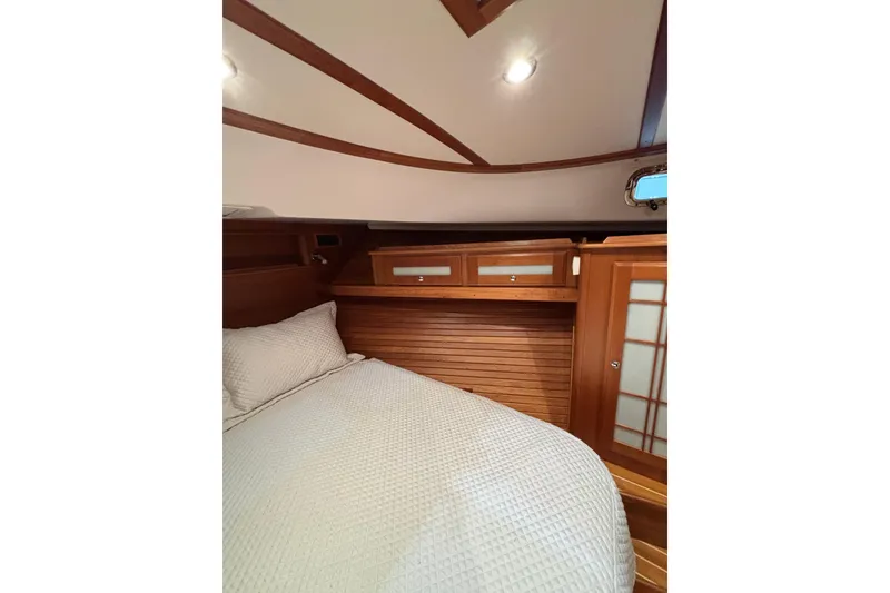 Slide: The Image of 2020 Sabre 45 Salon Express cabin with wooden interior and cozy bedding. - 49