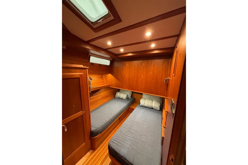 Slide: The Image of 2020 Sabre 45 Salon Express cabin with twin beds, wooden interior, and overhead lighting. - 51