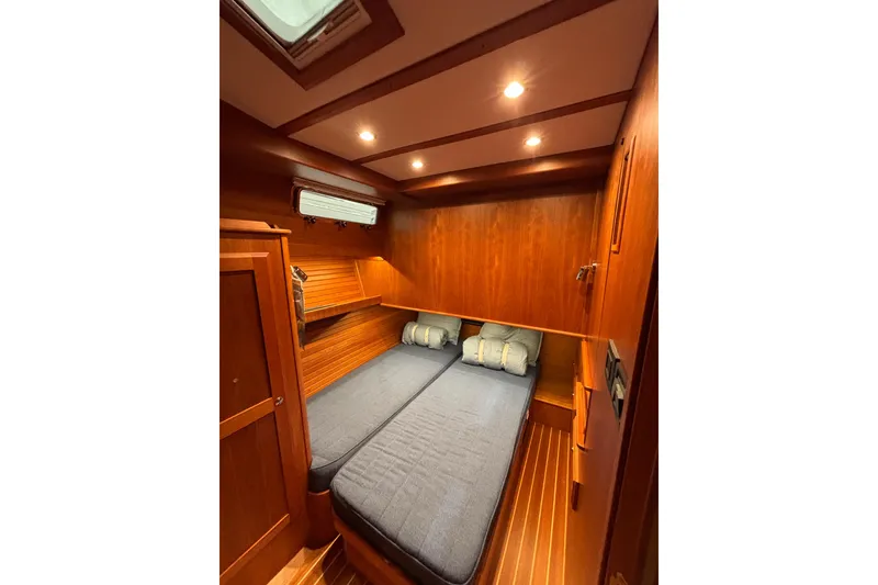 Slide: The Image of 2020 Sabre 45 Salon Express cabin with twin beds, wooden interior, and soft lighting. - 52