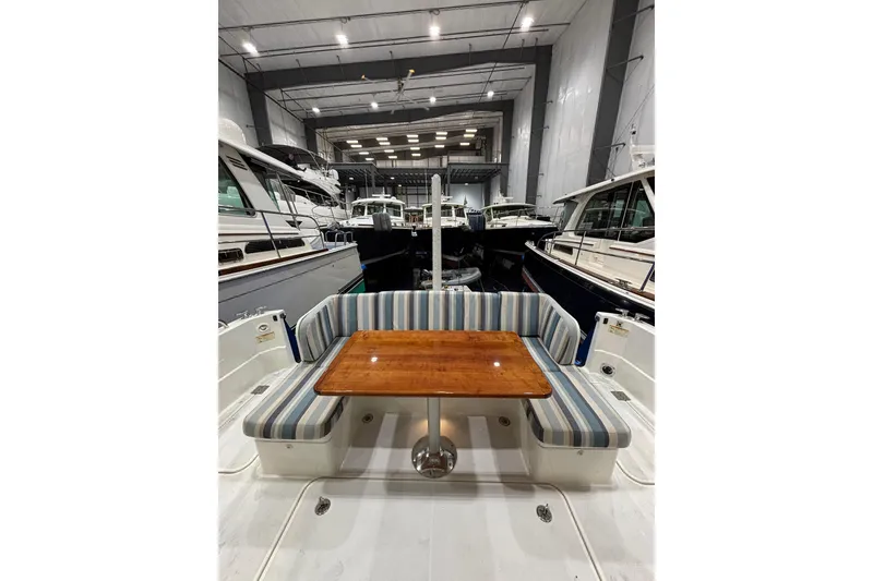Slide: The Image of 2020 Sabre 45 Salon Express yacht interior with striped seating and wooden table in a marina. - 61