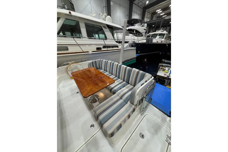 Slide: The Image of 2020 Sabre 45 Salon Express yacht interior with striped seating and wooden table. - 62