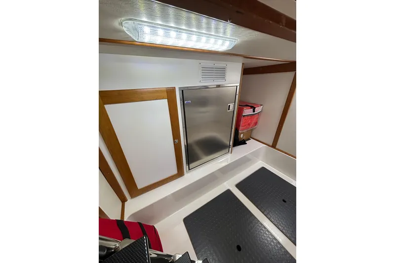 Slide: The Image of 2020 Sabre 45 Salon Express interior with stainless steel fridge and wooden accents. - 70