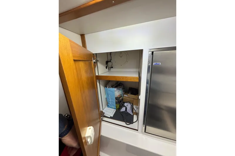 Slide: The Image of Open wooden cabinet on 2020 Sabre 45 Salon Express yacht, revealing storage items. - 75