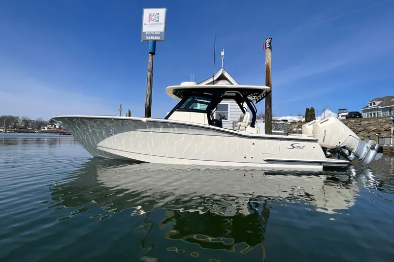 The Image of 2025 Scout 330 LXF boat docked on calm water under clear blue sky. - 0