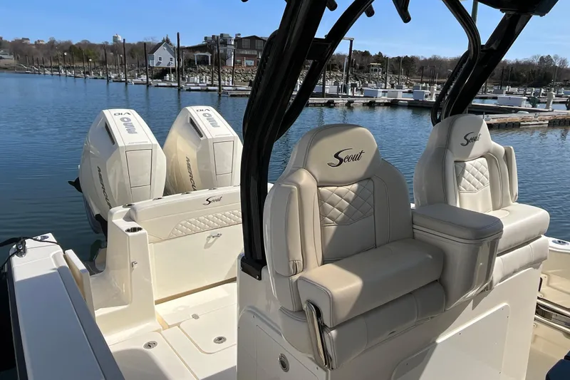 Slide: The Image of 2025 Scout 330 LXF boat with dual Mercury engines docked at marina. - 11