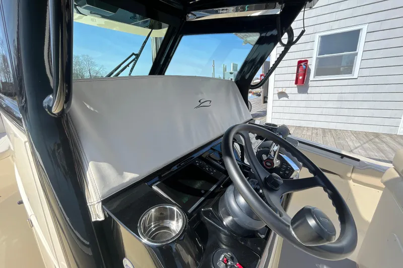 Slide: The Image of 2025 Scout 330 LXF boat helm with steering wheel and control panel. - 17
