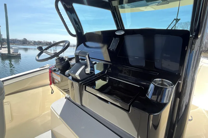 Slide: The Image of 2025 Scout 330 LXF boat helm with steering wheel and control panel. - 19