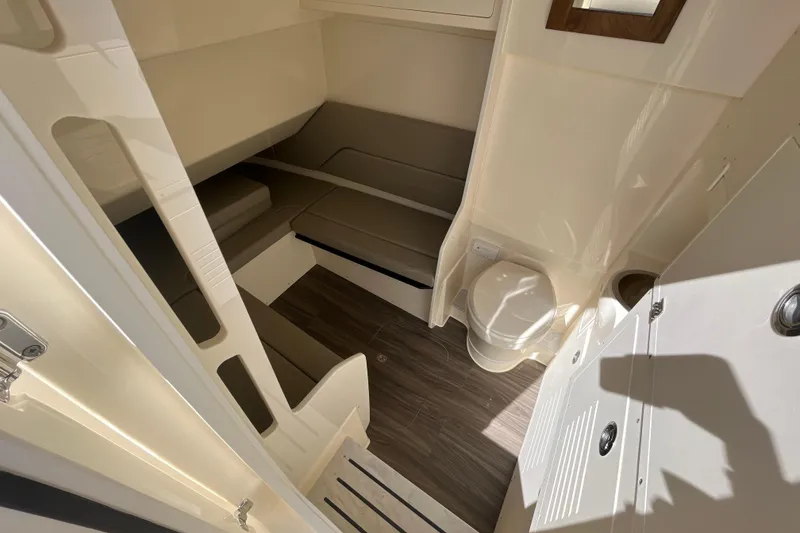 Slide: The Image of 2025 Scout 330 LXF cabin interior with seating and toilet, featuring modern design and wood flooring. - 23