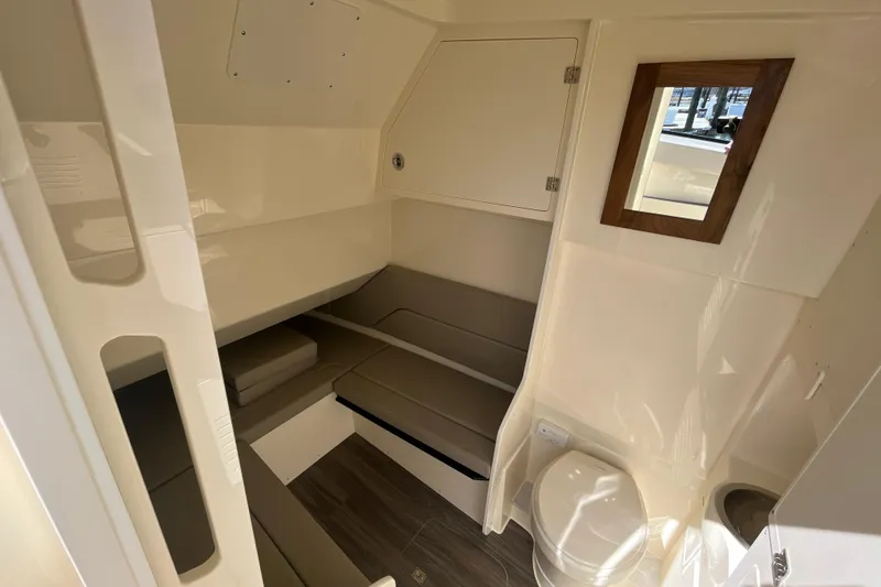Slide: The Image of 2025 Scout 330 LXF cabin interior with seating, toilet, and mirror. - 24