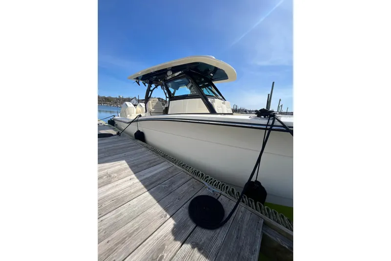 Slide: The Image of 2025 Scout 330 LXF boat docked under clear blue sky. - 7