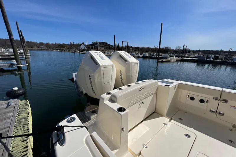 Slide: The Image of 2025 Scout 330 LXF boat docked with twin Mercury outboard engines. - 9