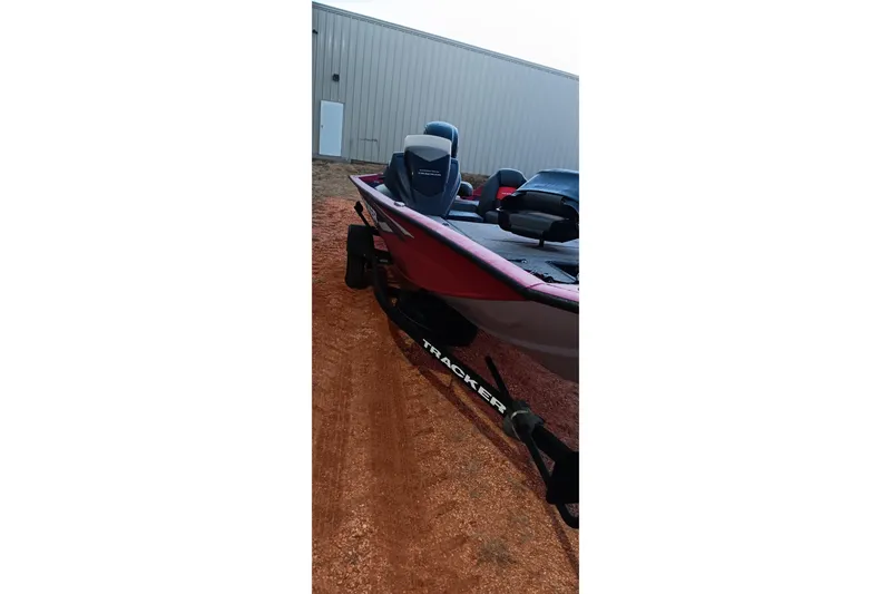 Slide: The Image of 2025 Tracker Pro Team 190 boat on trailer, parked near a building. - 18