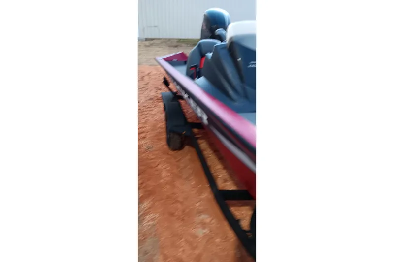 Slide: The Image of 2025 Tracker Pro Team 190 boat on trailer, parked on sandy ground. - 20