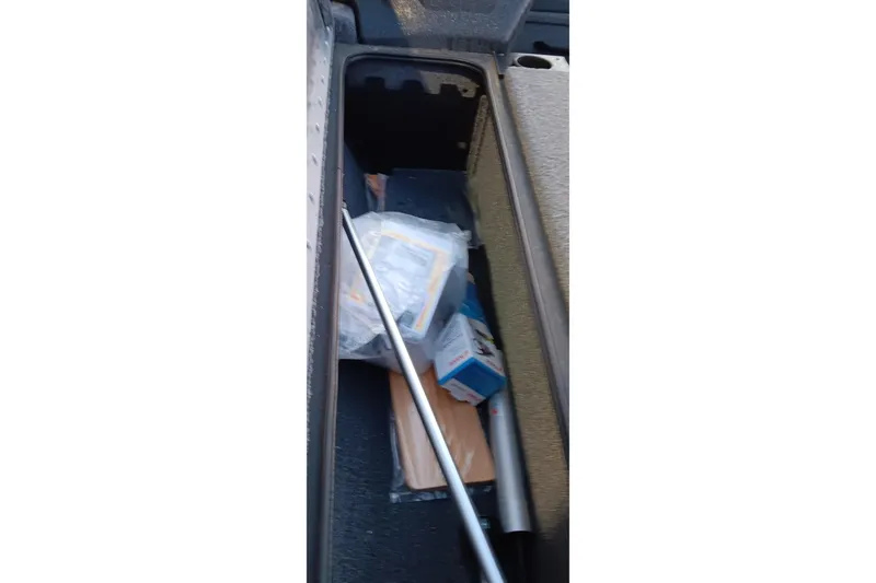 Slide: The Image of Storage compartment of 2025 Tracker Pro Team 190 boat with various items inside. - 21