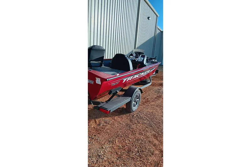 Slide: The Image of 2025 Tracker Pro Team 190 boat, red, parked on trailer near metal building. - 7