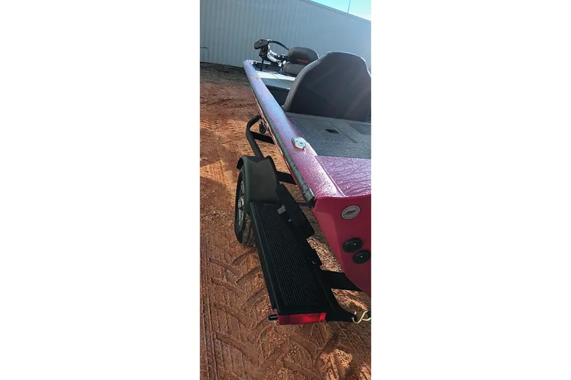 Slide: The Image of 2025 Tracker Pro Team 190 boat on trailer, rear view, parked on dirt surface. - 8