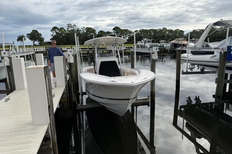 The Image of 2015 Regulator 25 boat cruising on a scenic waterway under a cloudy sky. - 0