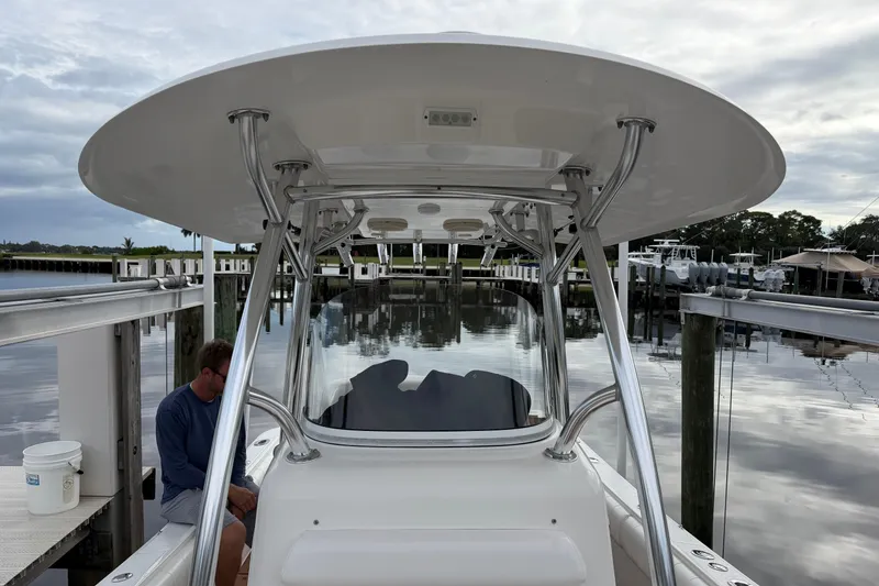 Slide: The Image of 2015 Regulator 25 boat interior with white seating and teak flooring. - 17
