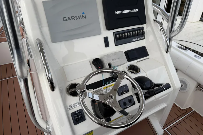 Slide: The Image of 2015 Regulator 25 boat with rod holders under a cloudy sky. - 26