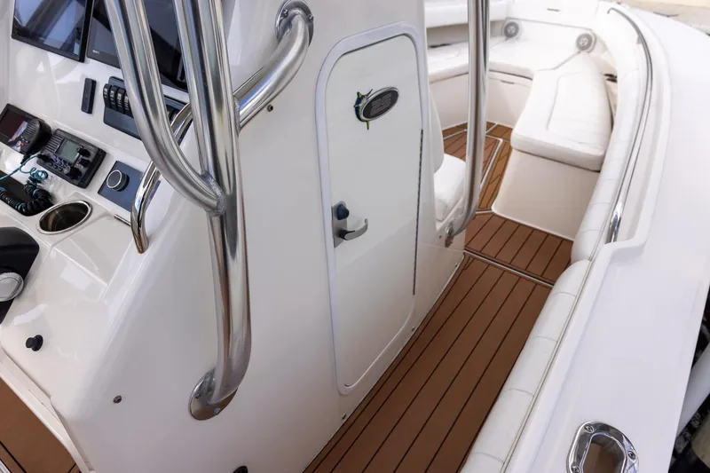 Slide: The Image of 2015 Regulator 25 boat interior with helm, seating, and teak flooring. - 29