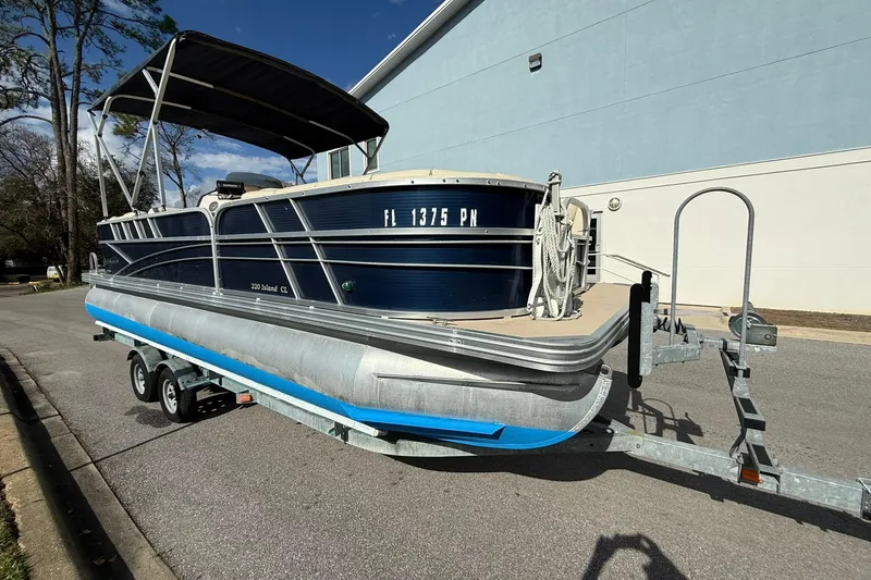Slide: The Image of 2013 Silver Wave 220 Island CL pontoon boat on trailer, parked outdoors. - 2