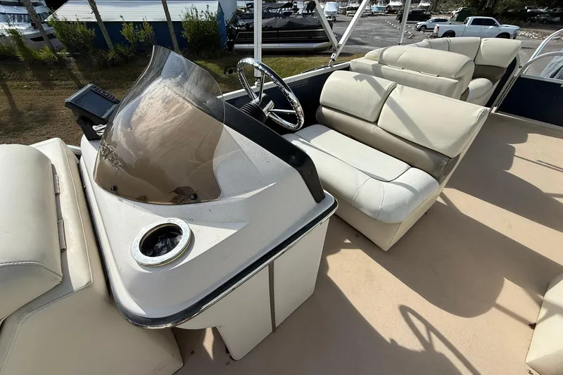 Slide: The Image of 2013 Silver Wave 220 Island CL boat interior with beige seating and steering console. - 8