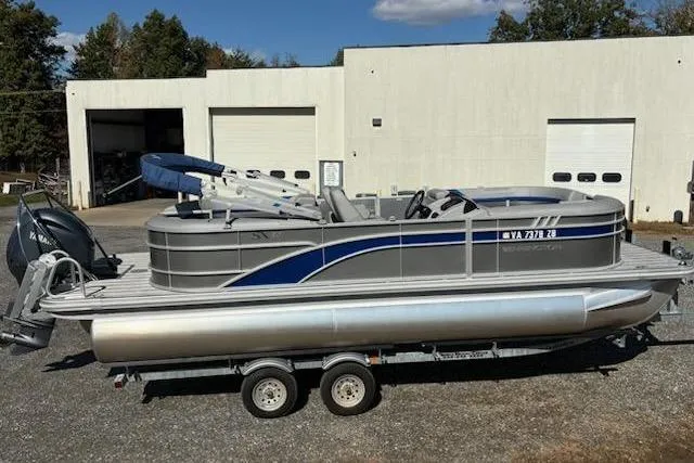 Slide: The Image of 2025 Bennington 22SXSR pontoon boat on trailer, parked outside a warehouse. - 5